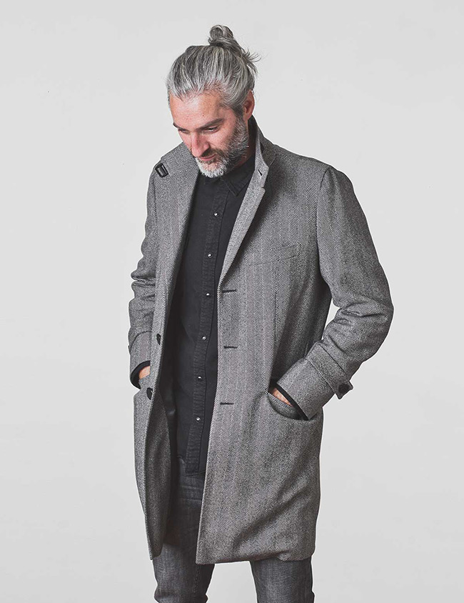 Modelo con abrigo de espiga para hombre color gris. Sastrería Brune.
