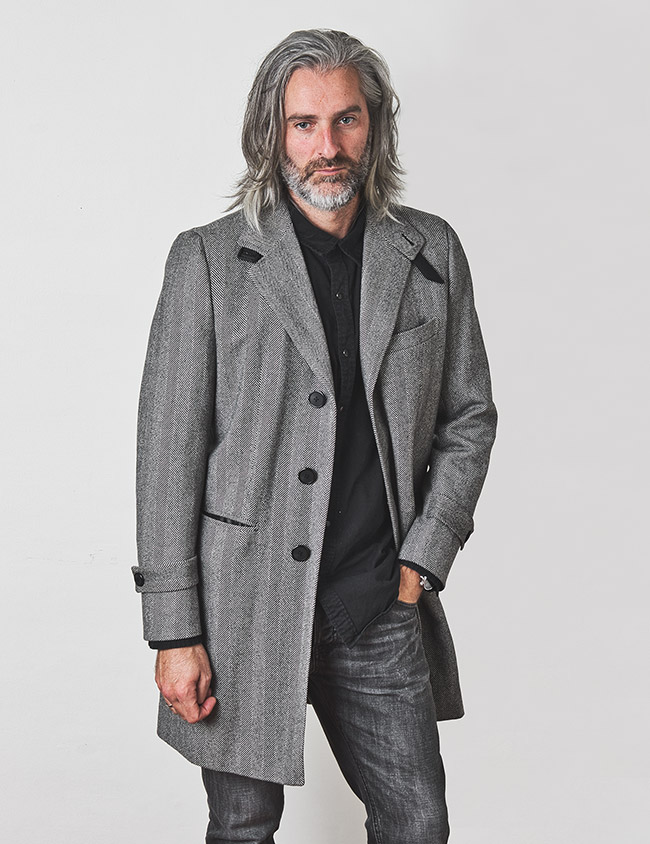 Modelo con abrigo de espiga para hombre color gris. Sastrería Brune.