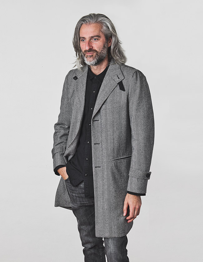 Modelo con abrigo de espiga para hombre color gris. Sastrería Brune.