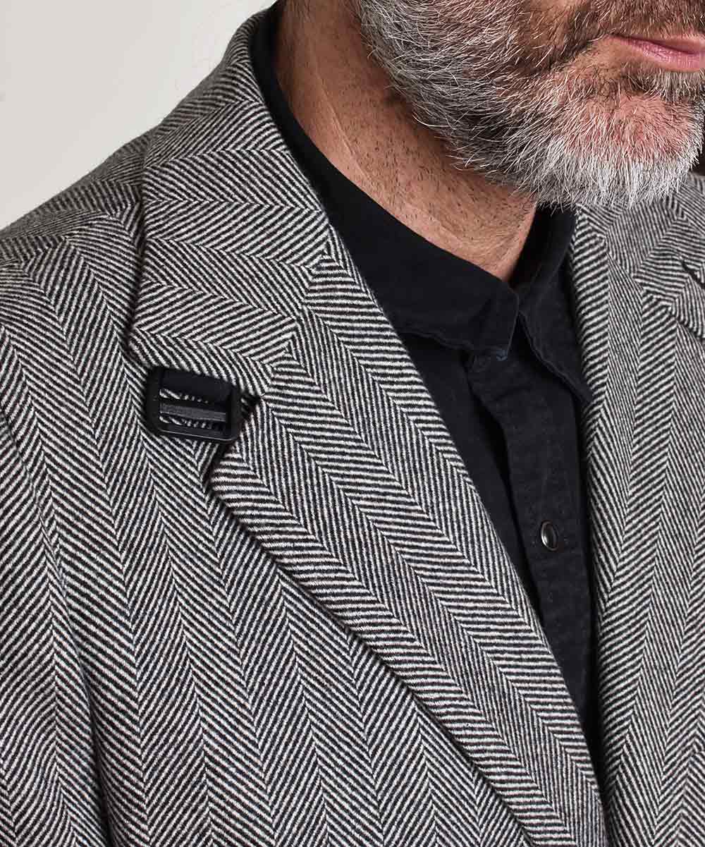 Detalle de cuello con hebilla en abrigo de espiga de hombre. 